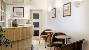 Un intérieur moderne avec un comptoir incurvé, des chaises en bois et des œuvres d’art encadrées accrochées aux murs.