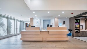 Un mostrador de recepción de hotel con un diseño moderno, un ventanal grande y una puerta a la vista.