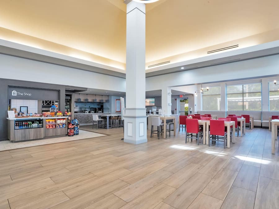 A spacious indoor area with a food counter, seating area, and a visible exit sign.