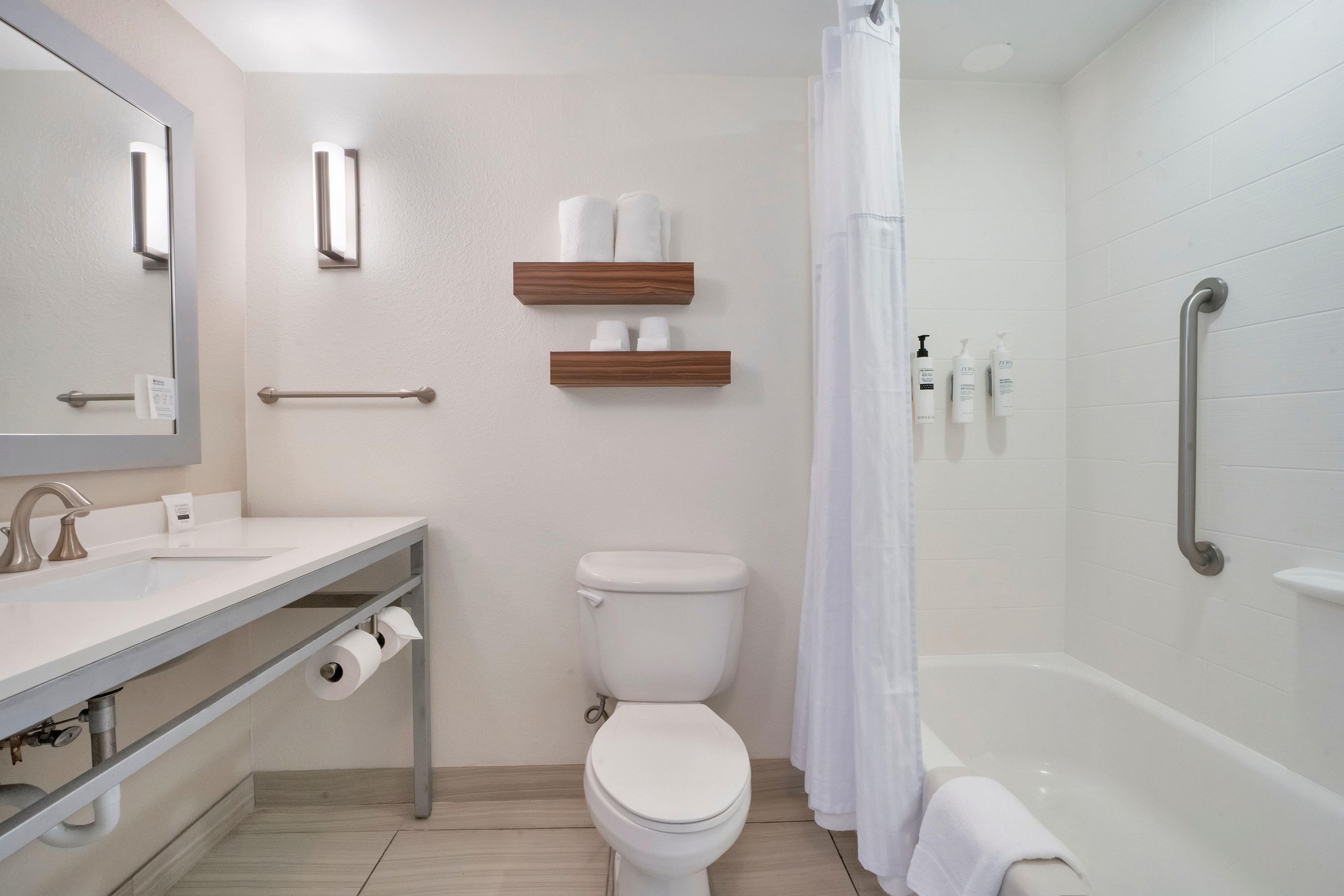 Une salle de bain moderne équipée de toilettes, d’un lavabo et d’un espace douche.