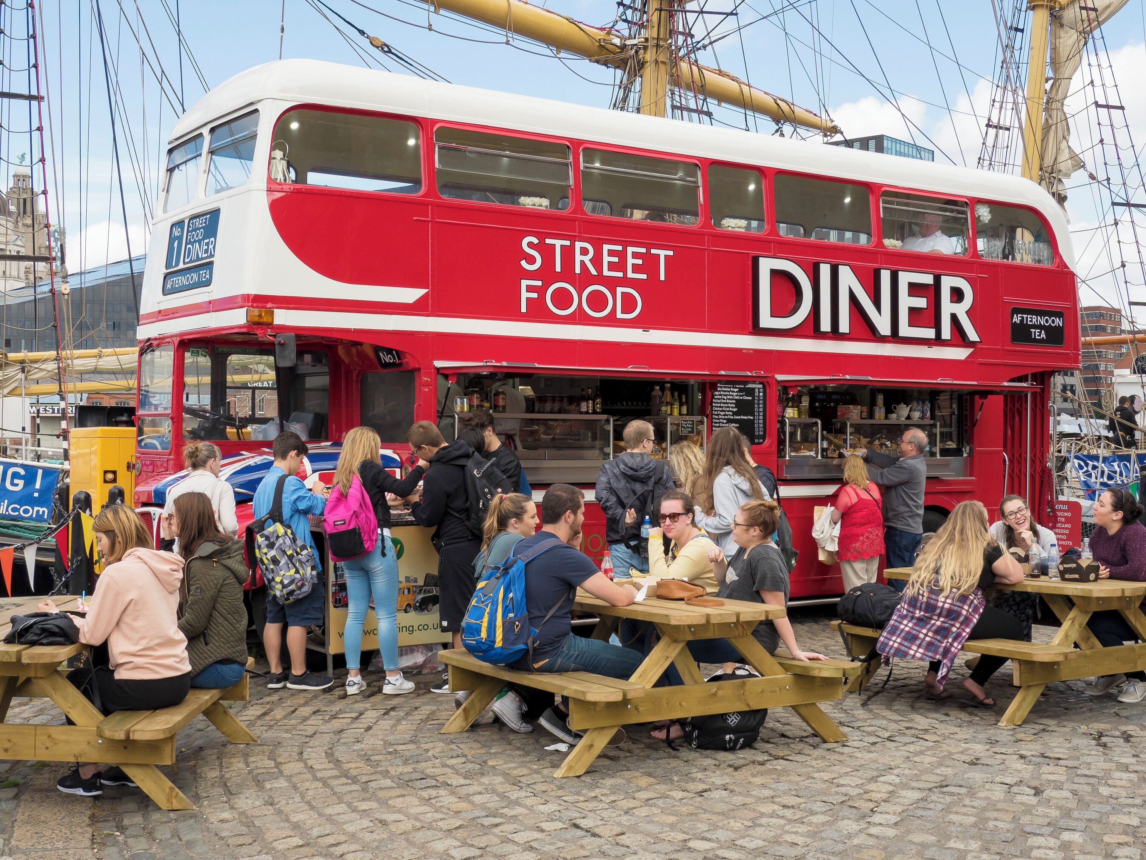 A red and white street food diner with outdoor seating.