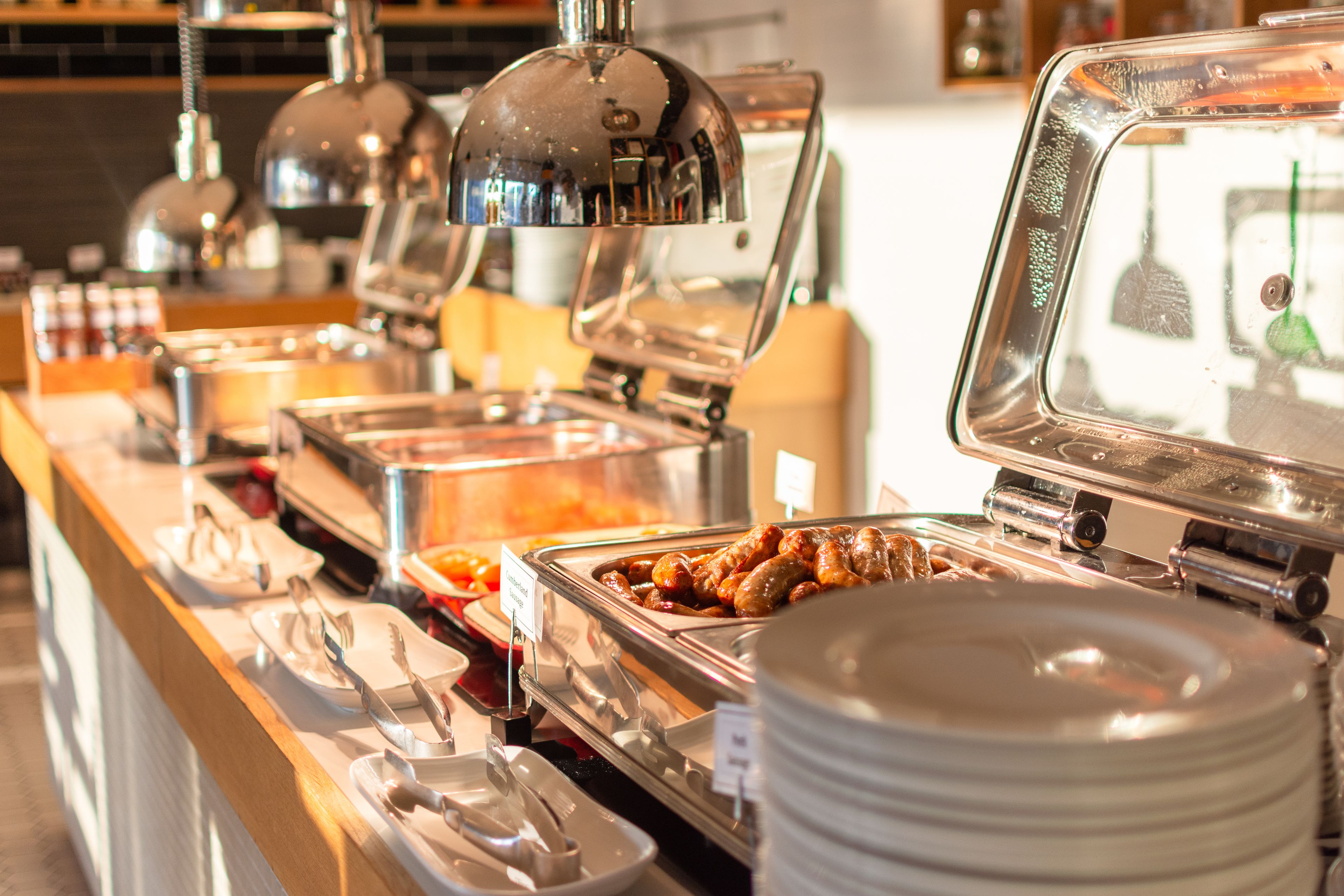 A buffet with various food items and utensils.
