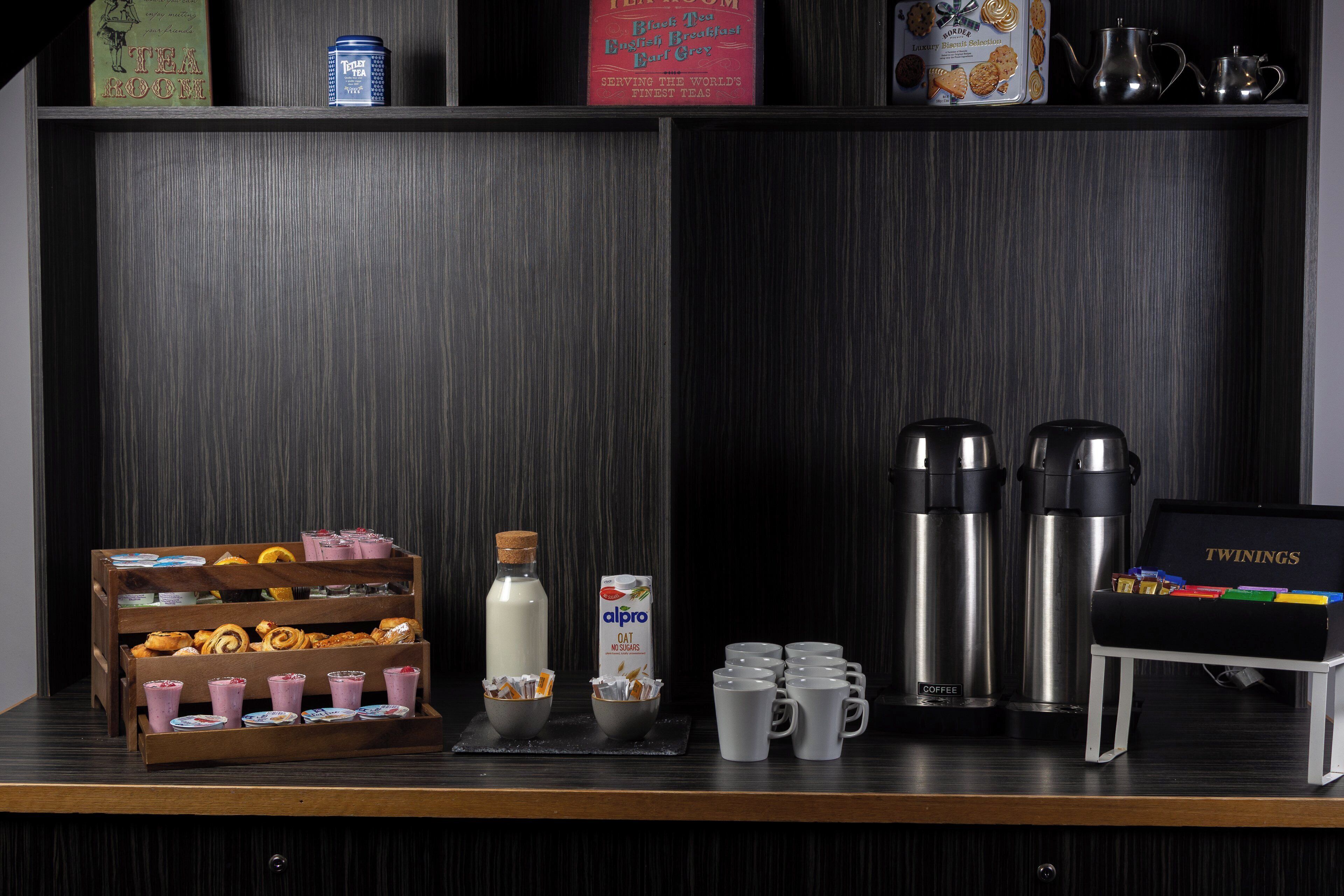 A breakfast buffet setup with various food items and beverages.