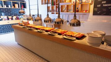 Un área de buffet con diferentes alimentos y salsas.