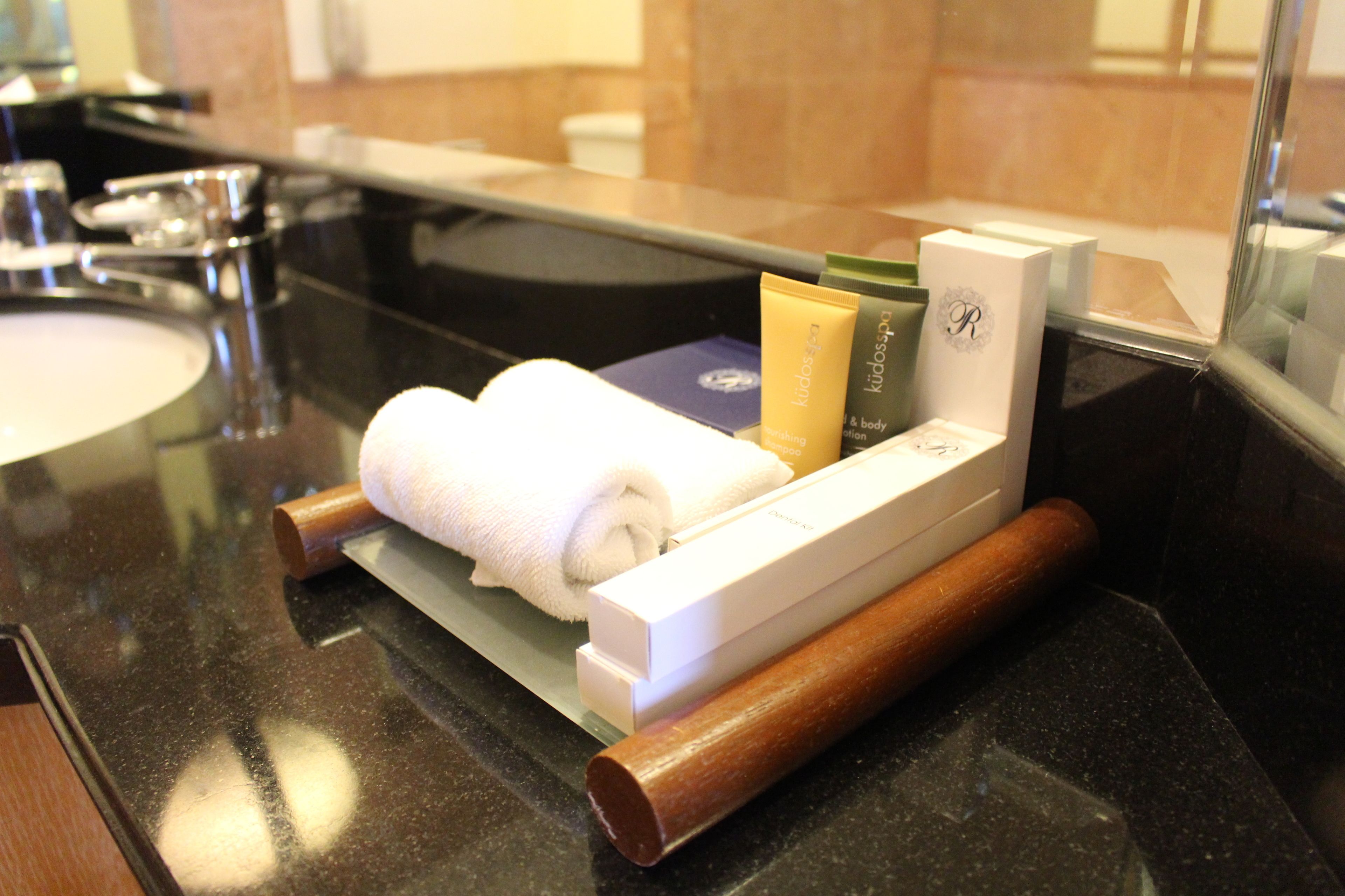 Una encimera de baño con una toalla, un dispensador de jabón y un afeitor.