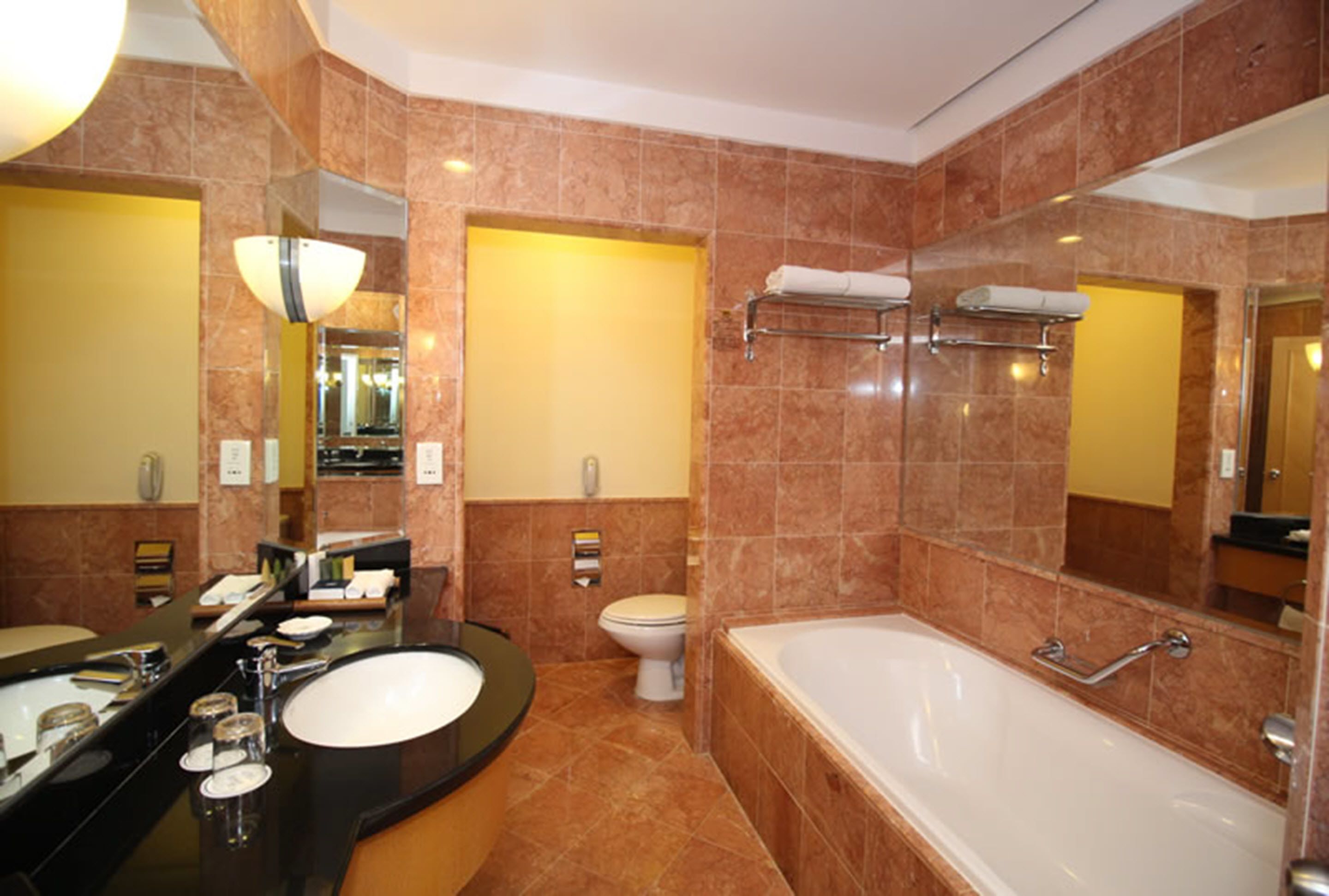 A modern bathroom with a large bathtub, a double sink vanity, and a toilet.