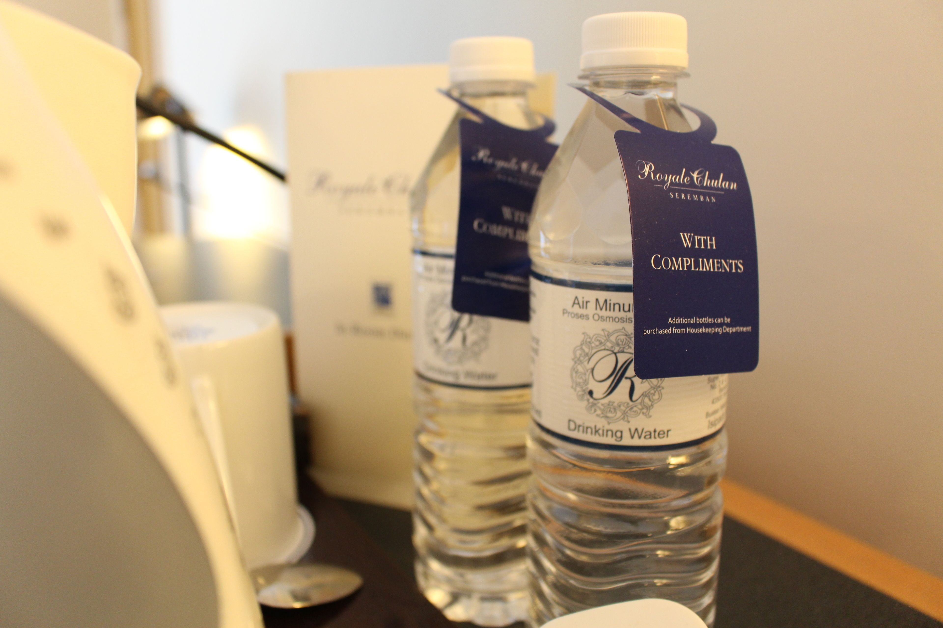 A bottle of water labeled "Royal Chalana" with a tag that reads "With Compliments."