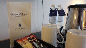 A tray with a menu, coffee machine, and bottled water.