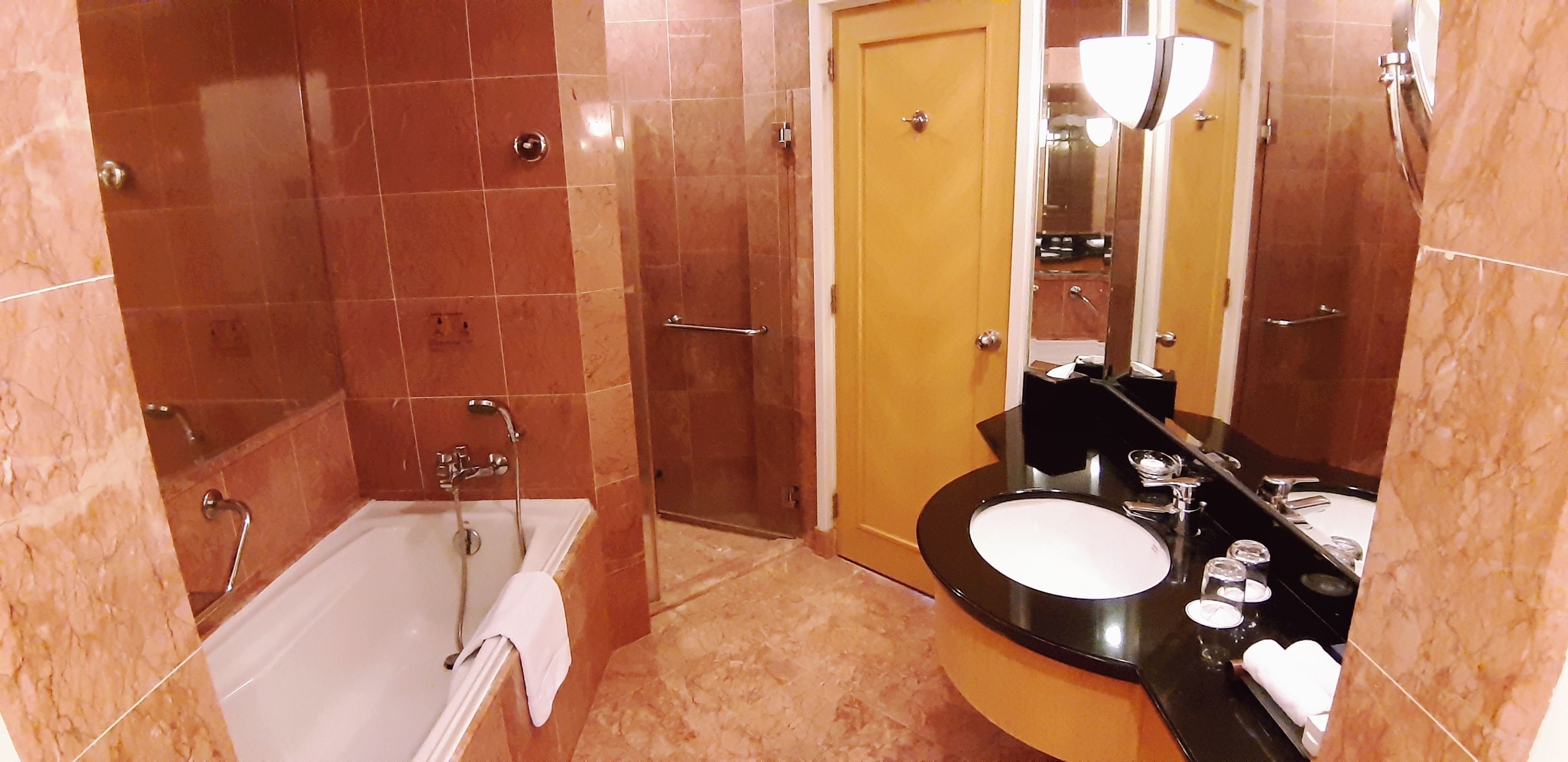 A bathroom with a bathtub, a sink, and a mirror.