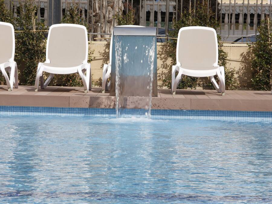 Alberca al aire libre y camastros