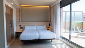 A modern hotel room with a double bed, wooden headboard, bedside tables, and a large window offering a view of the outdoors. - HOTEL SANT PAU (Barcelona)