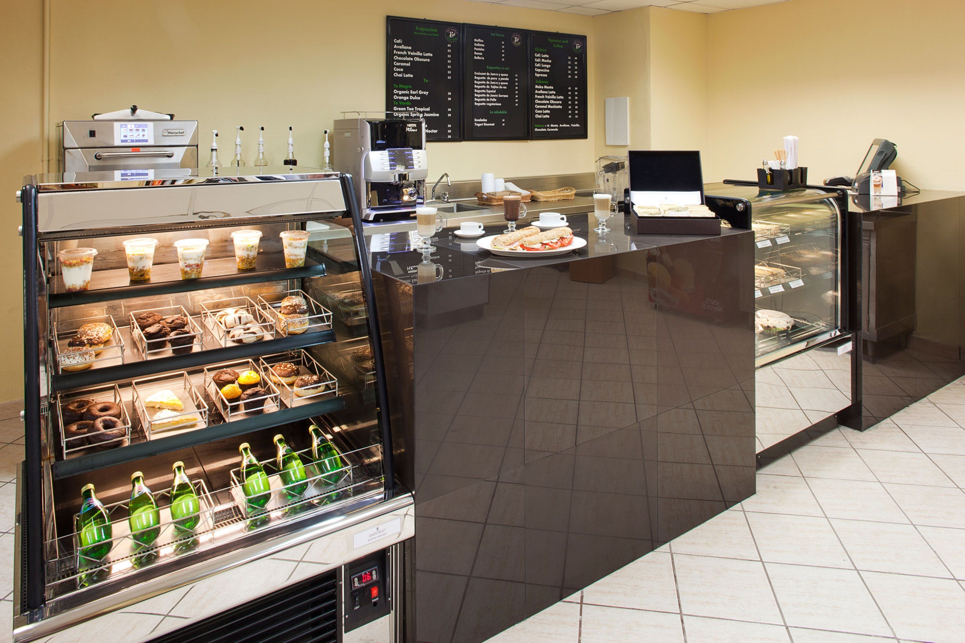 A bakery counter with various baked goods and a coffee machine.