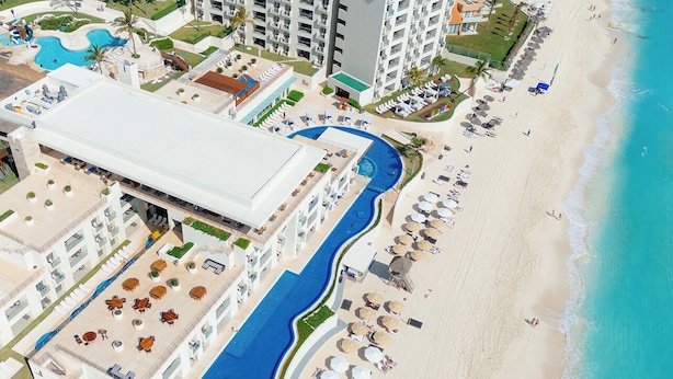 An aerial view of a resort with a large pool, beach, and multiple buildings. - Emporio Cancun Optional All Inclusive (Cancun)