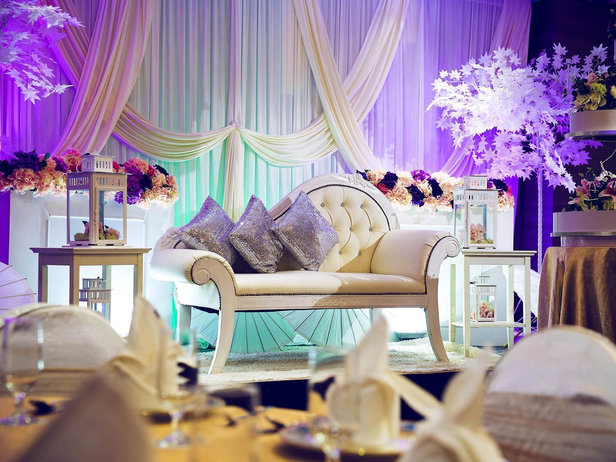Una habitación lujosa con un sofá mullido, cortinas elegantes e iluminación decorativa.