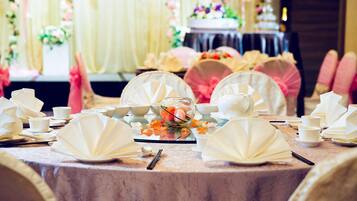A table set for a formal event with white tableware and floral decorations.