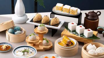 Diverse Aziatische gerechten, waaronder dumplings, rijsttaartjes en een theepot.