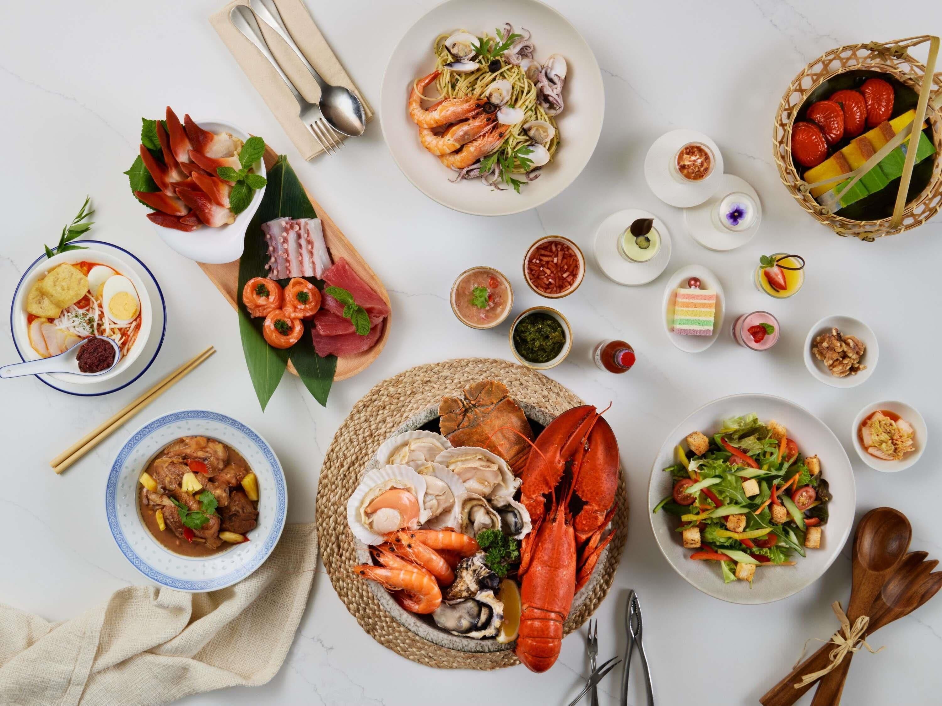 Una variedad de platos que incluyen mariscos, ensaladas y postres, dispuestos sobre una mesa.
