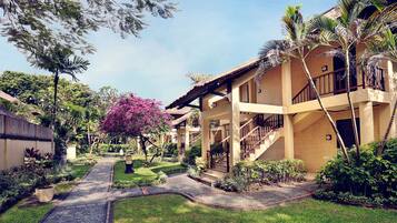 A resort with a central pathway, multiple buildings, and lush greenery.