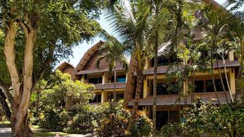 A resort with multiple-story buildings, palm trees, and a well-maintained garden.