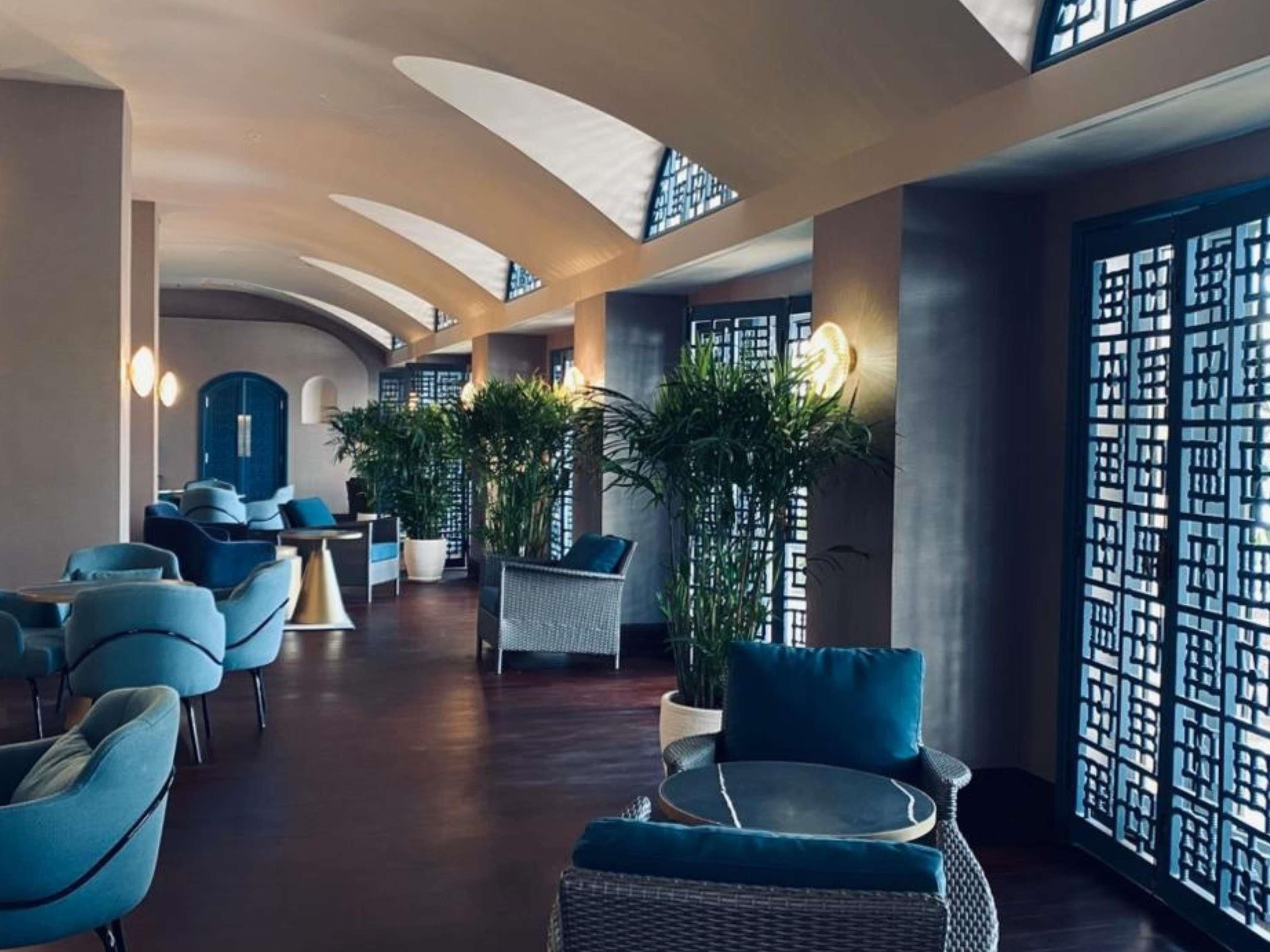 A spacious lobby with modern seating, large windows, and decorative plants.