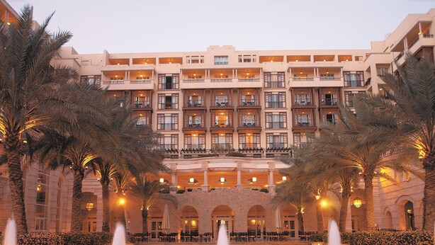 A multi-story hotel with a central courtyard, palm trees, and a pool with fountains. - Mövenpick Resort & Residences Aqaba (Aqaba)