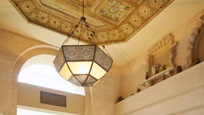 A spacious lobby with a fountain, a high ornate ceiling, and a large window allowing natural light. - Mövenpick Resort & Residences Aqaba (Aqaba)
