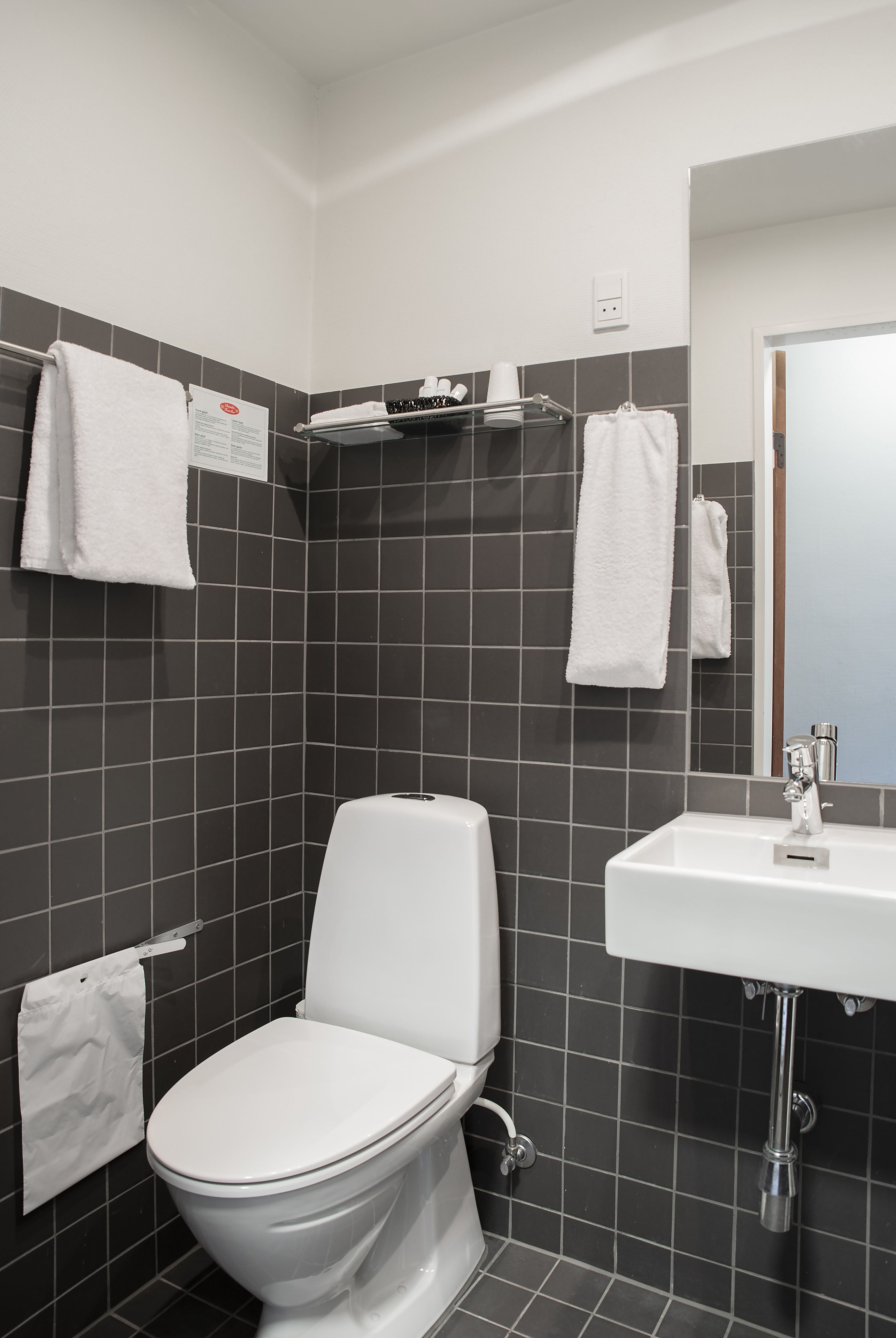 Ein modernes Badezimmer mit Toilette, Waschbecken und Duschbereich.