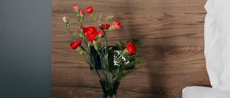 A vase with red flowers on a wooden surface.