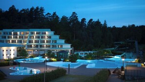 Ein mehrstöckiges Hotel mit Poolbereich, inklusive Wasserrutsche und mehreren Pools.