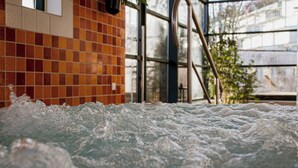 Ein Whirlpool mit einer gefliesten Wand im Hintergrund.
