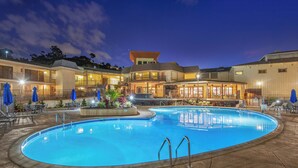 A swimming pool with a surrounding patio area, lounge chairs, and a building with multiple balconies. - Crowne Plaza San Diego - Mission Valley by IHG (San Diego)