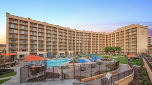 A hotel with a large pool area, outdoor seating, and a well-maintained garden. - Crowne Plaza San Diego - Mission Valley by IHG (San Diego)