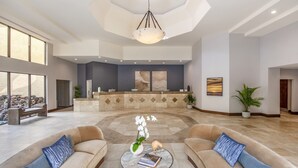 A spacious lobby with two sofas, a reception desk, and a large chandelier. - Crowne Plaza San Diego - Mission Valley by IHG (San Diego)