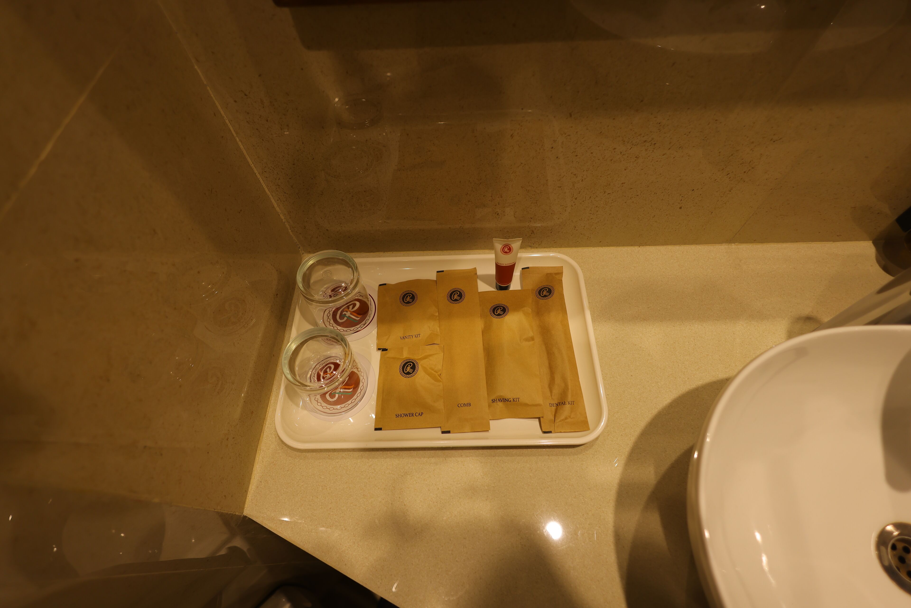 Ein Badezimmer mit einem weißen Waschbecken, einer Ablage mit Pflegeprodukten und einer Duschhaube.