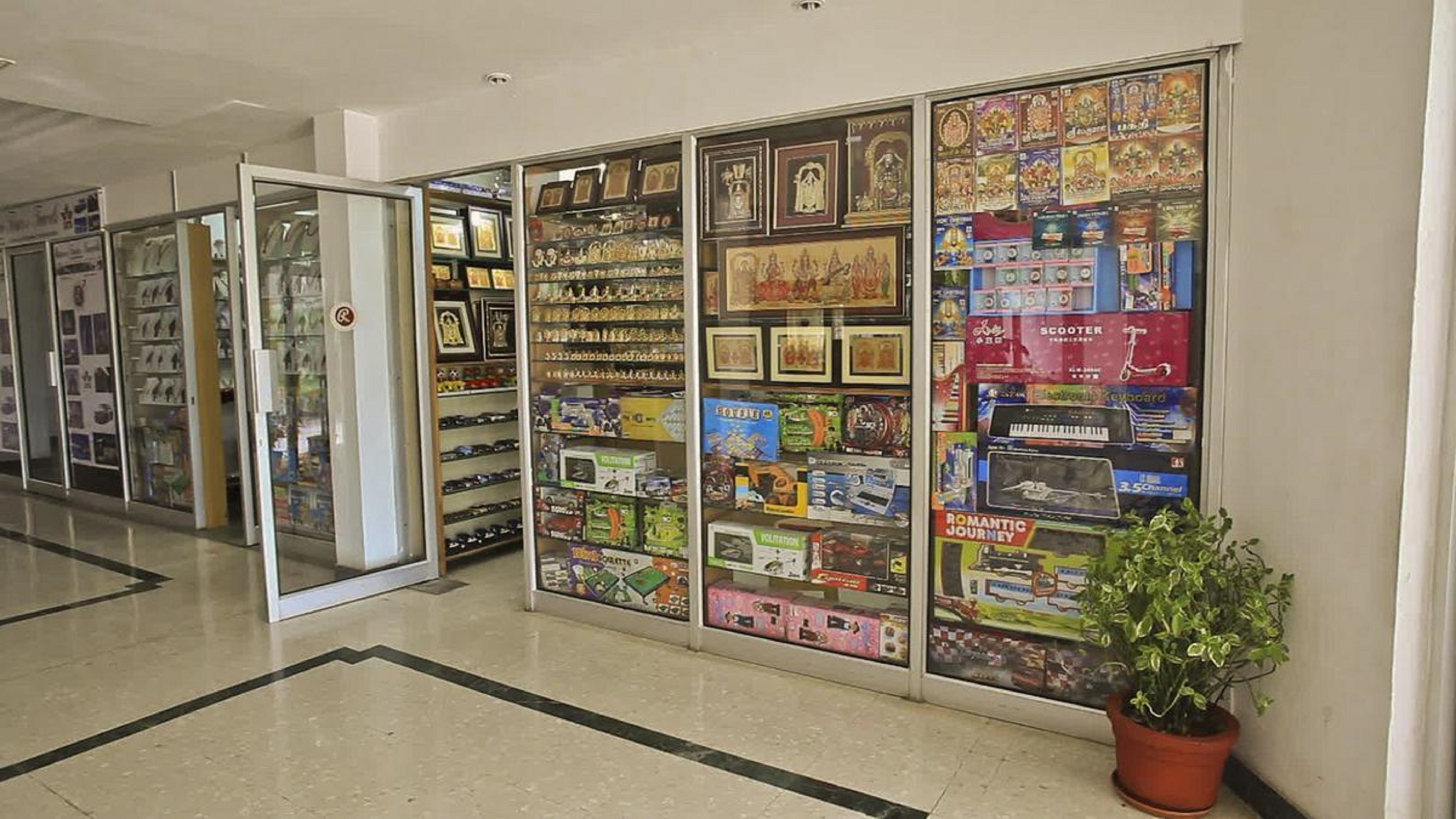 A corridor with glass display cases filled with various items, including toys and collectibles.