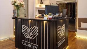 Un mostrador de recepción de diseño moderno, que muestra un logotipo y el nombre 'NAMASTE SPA'.