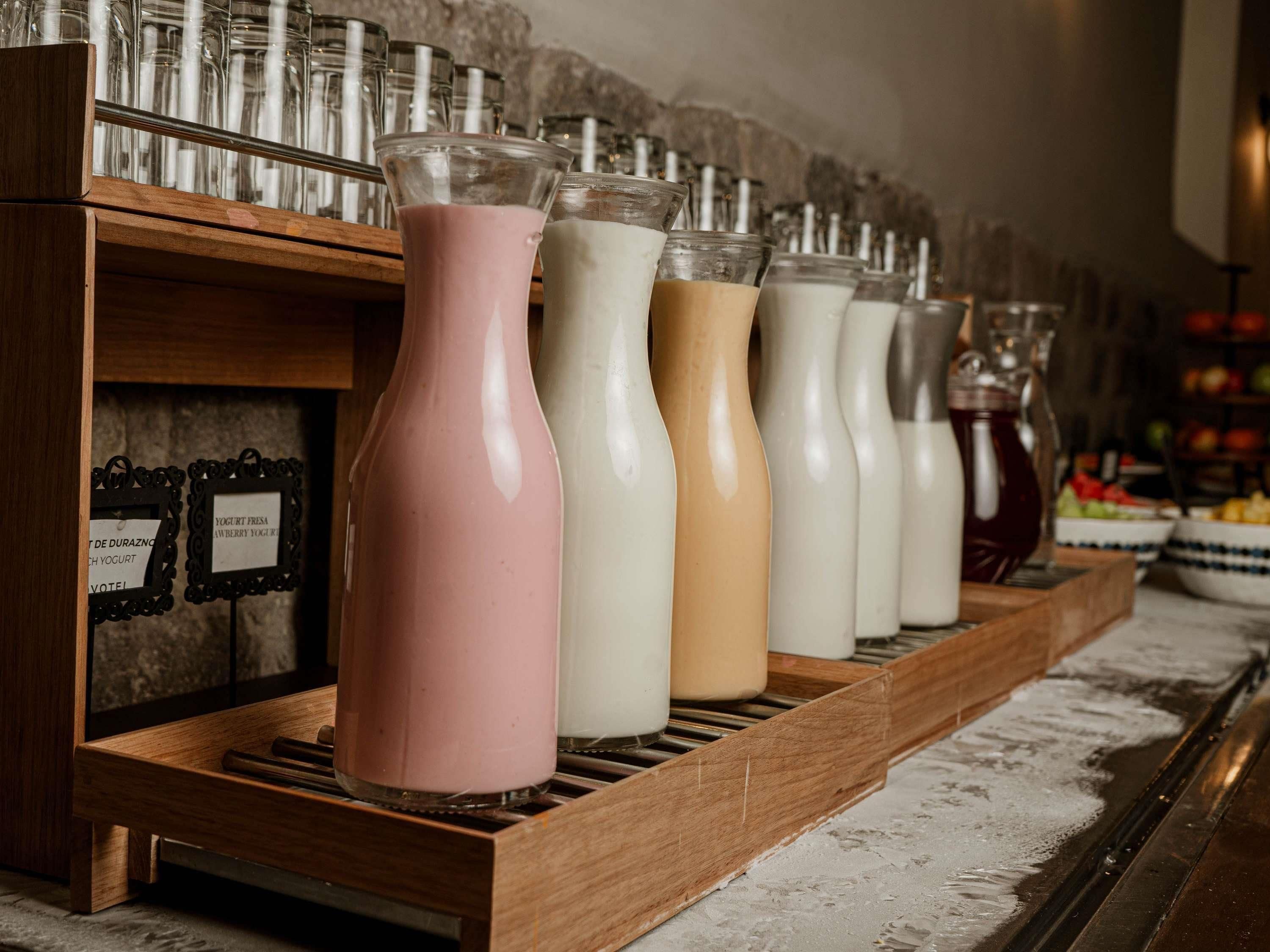 A row of yogurt containers on a wooden shelf.