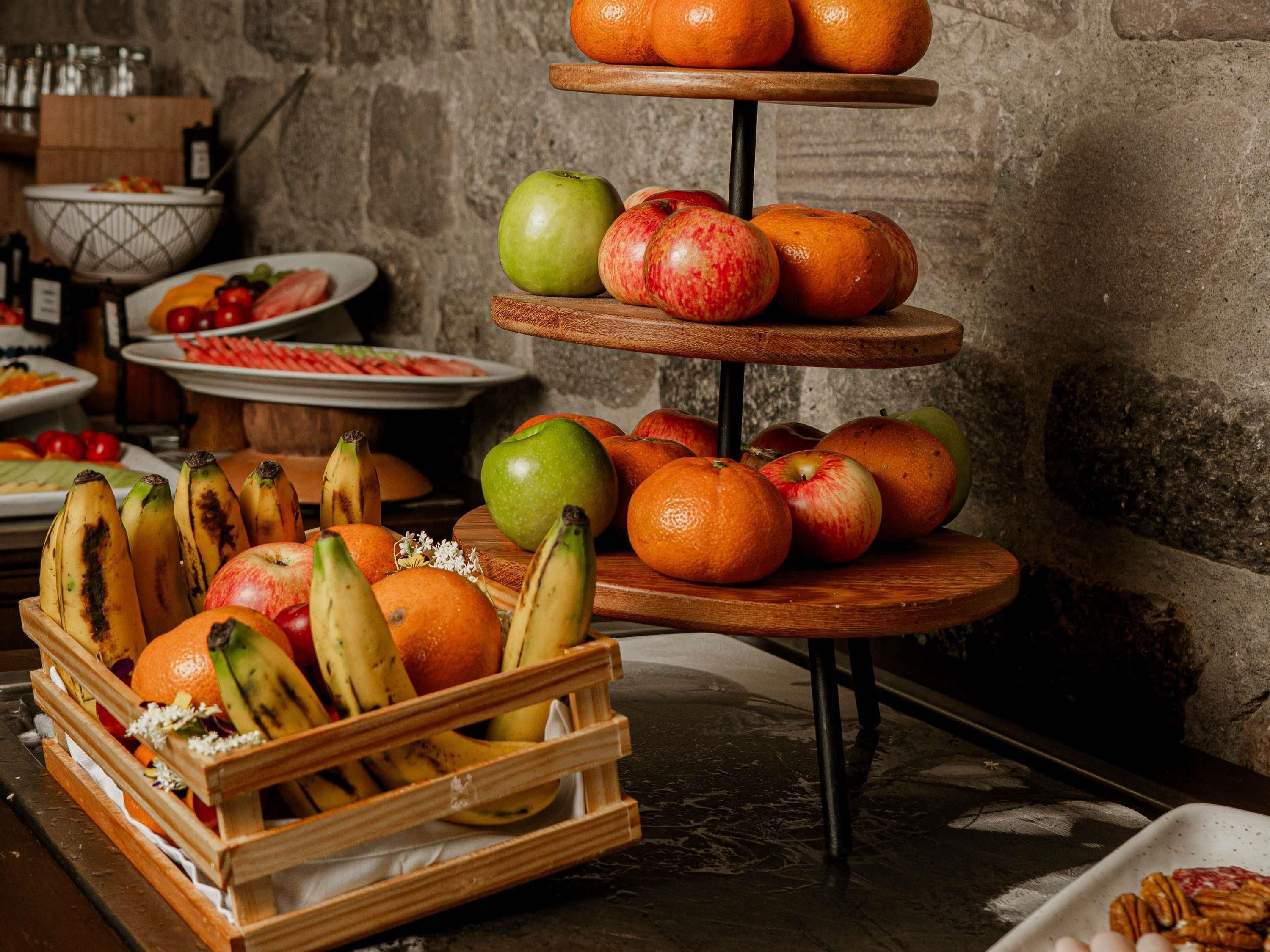 A fruit display with apples, oranges, and bananas.