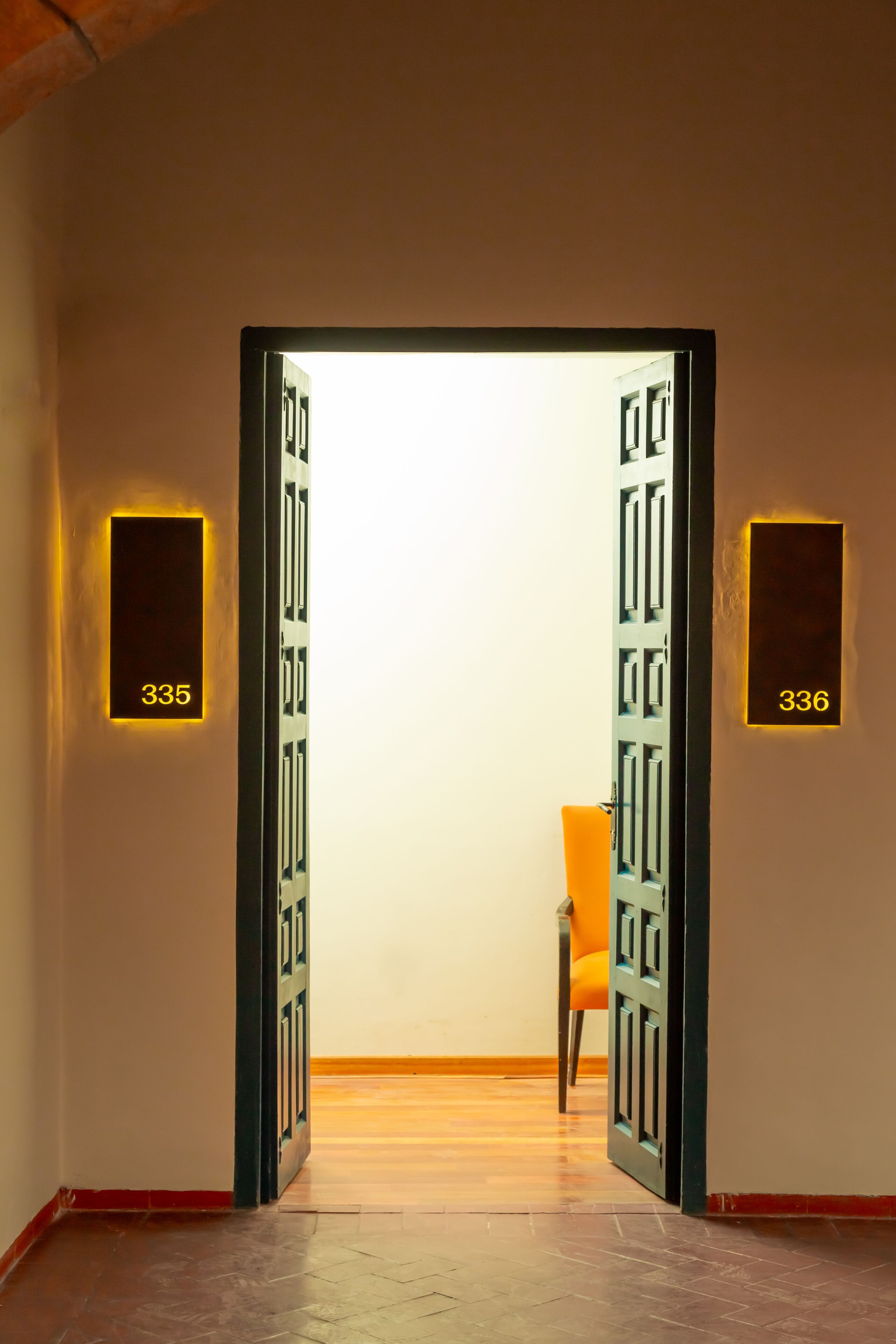 An open door leading to a room with a number 335 sign on the wall.