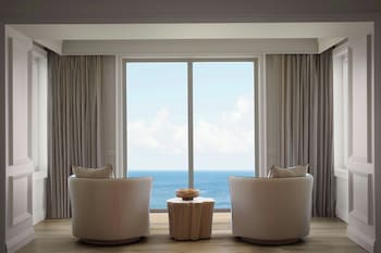 A modern interior with wooden tables and benches, a reception desk, and a check-in counter. at The Ritz-Carlton Key Biscayne, Miami