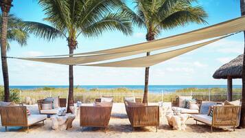 En la playa, camas de playa, sillas reclinables de playa, sombrillas