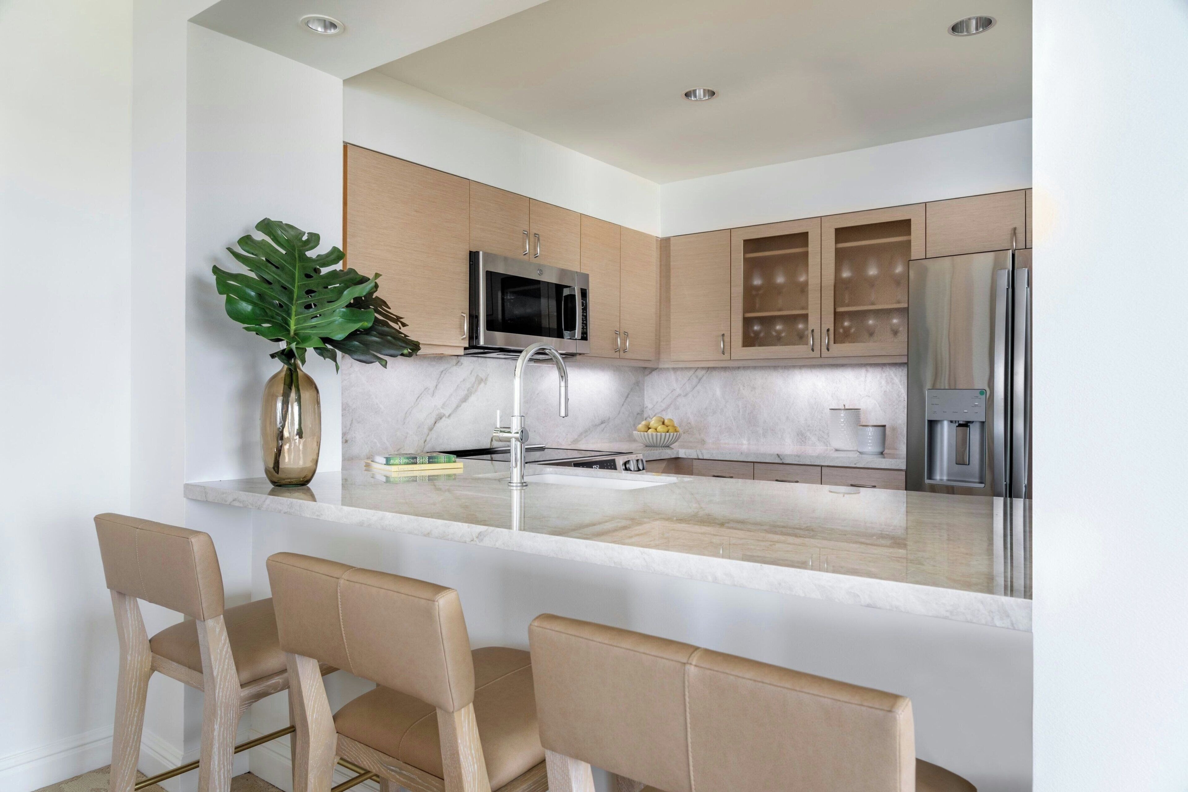 A modern kitchen with a central island, stainless steel appliances, and wooden cabinets.