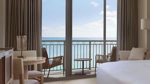 A hotel room with a large window, a bed, a round table, and two chairs.