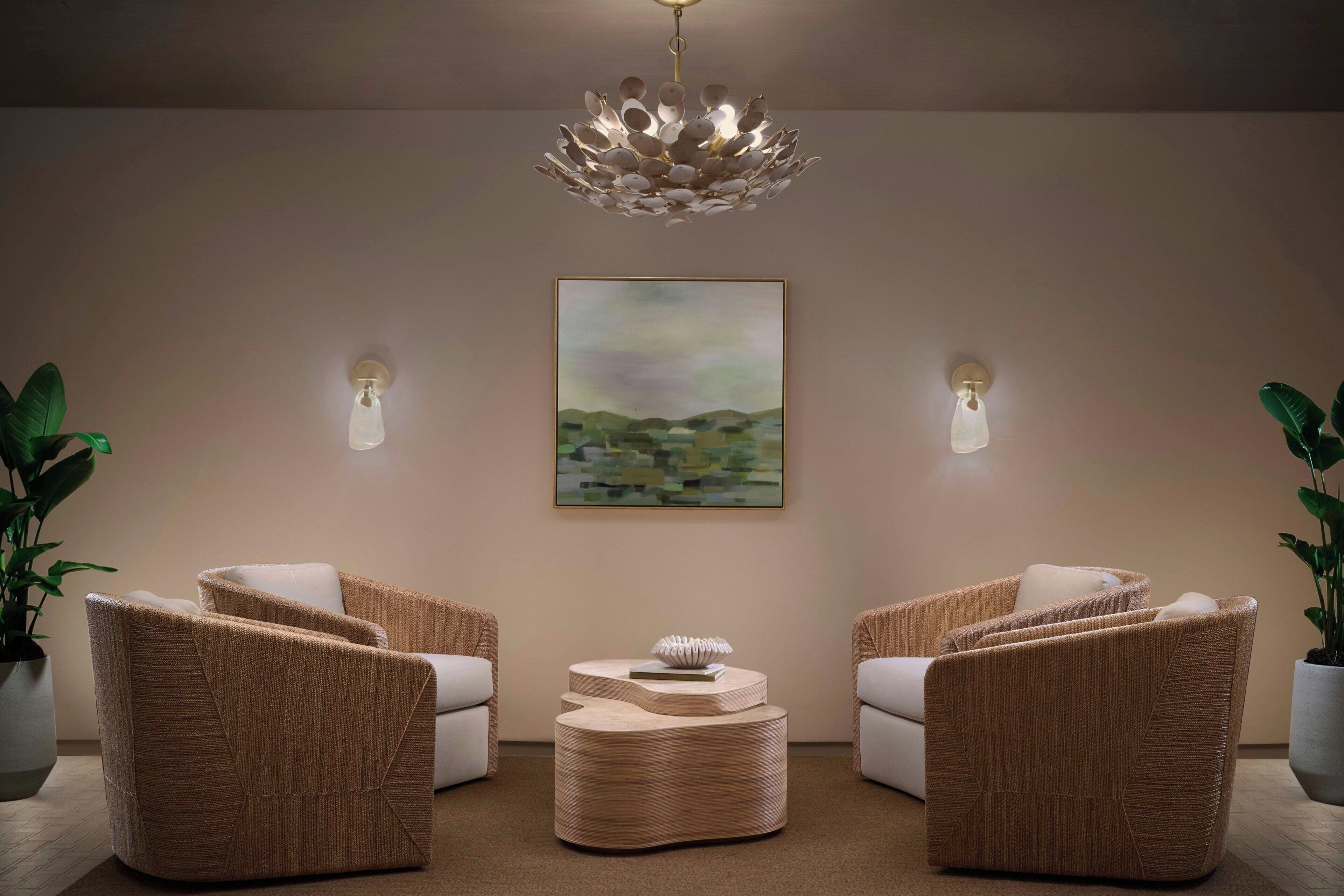 A modern lounge area with two sofas, a central coffee table, and a painting on the wall.