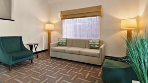 A room with a sofa, a chair, a small table, and a lamp. - Quality Inn Memphis Northeast near I-40 (Memphis)