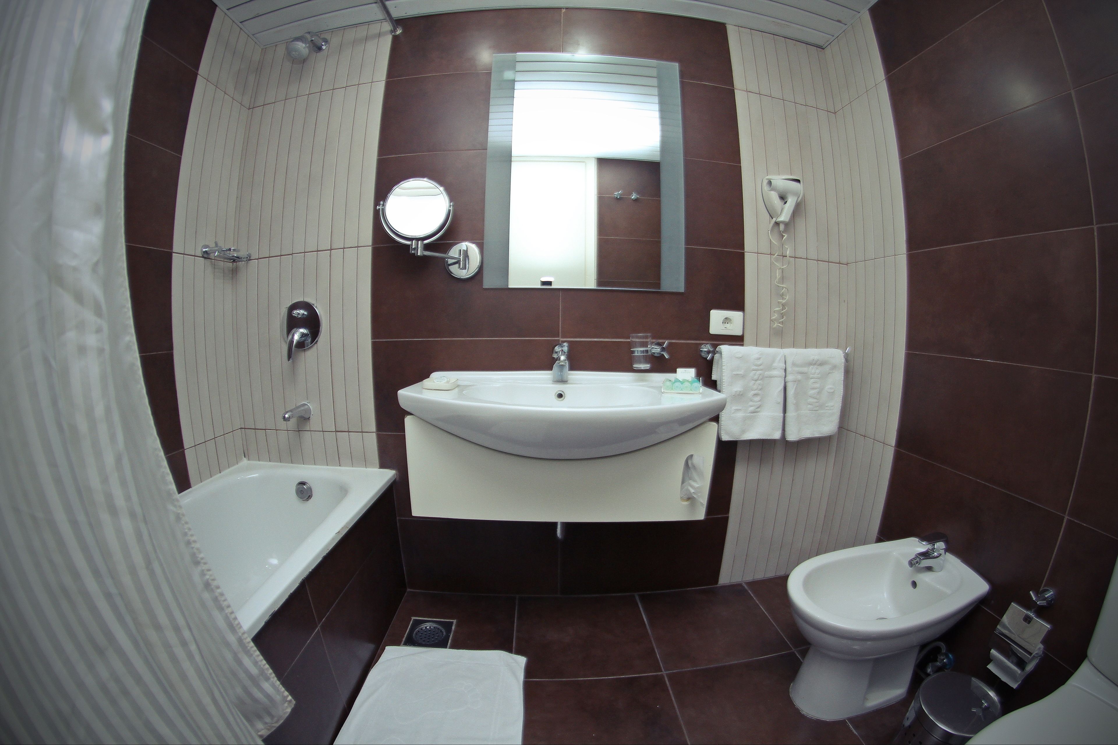 Une salle de bain équipée d’un lavabo, d’un miroir, d’une douche et d’un bidet.