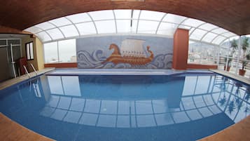 Swim beneath a glass ceiling, surrounded by a wooden deck and a unique mural.