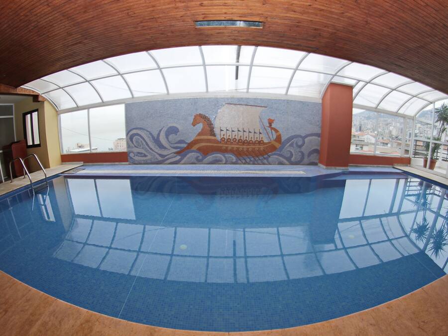 Una piscina cubierta, tumbonas