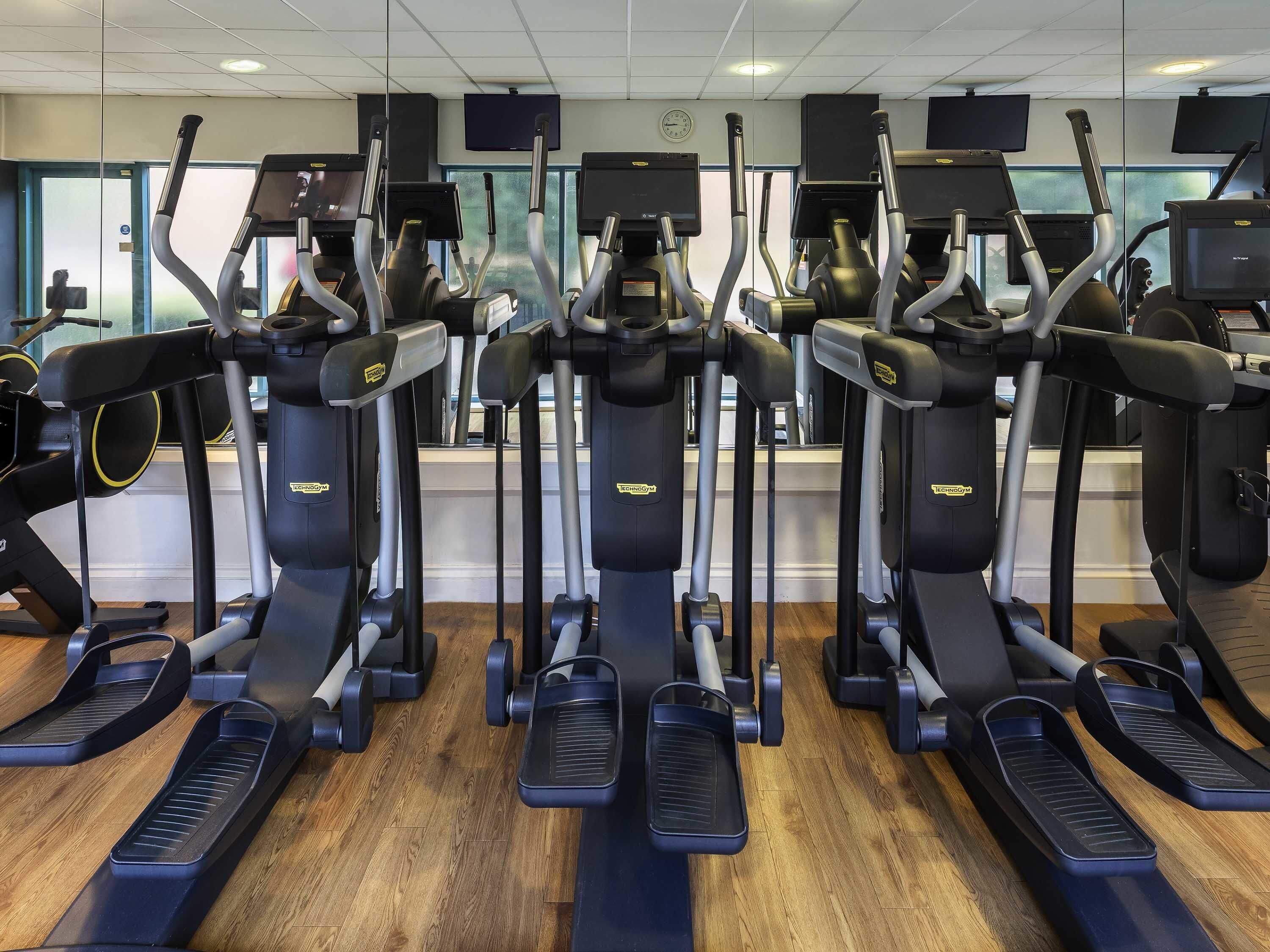 A gym with treadmills, ellipticals, and weights.