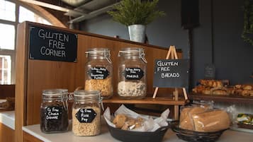 A gluten-free corner with labeled jars of snacks and a sign indicating gluten-free breads.
